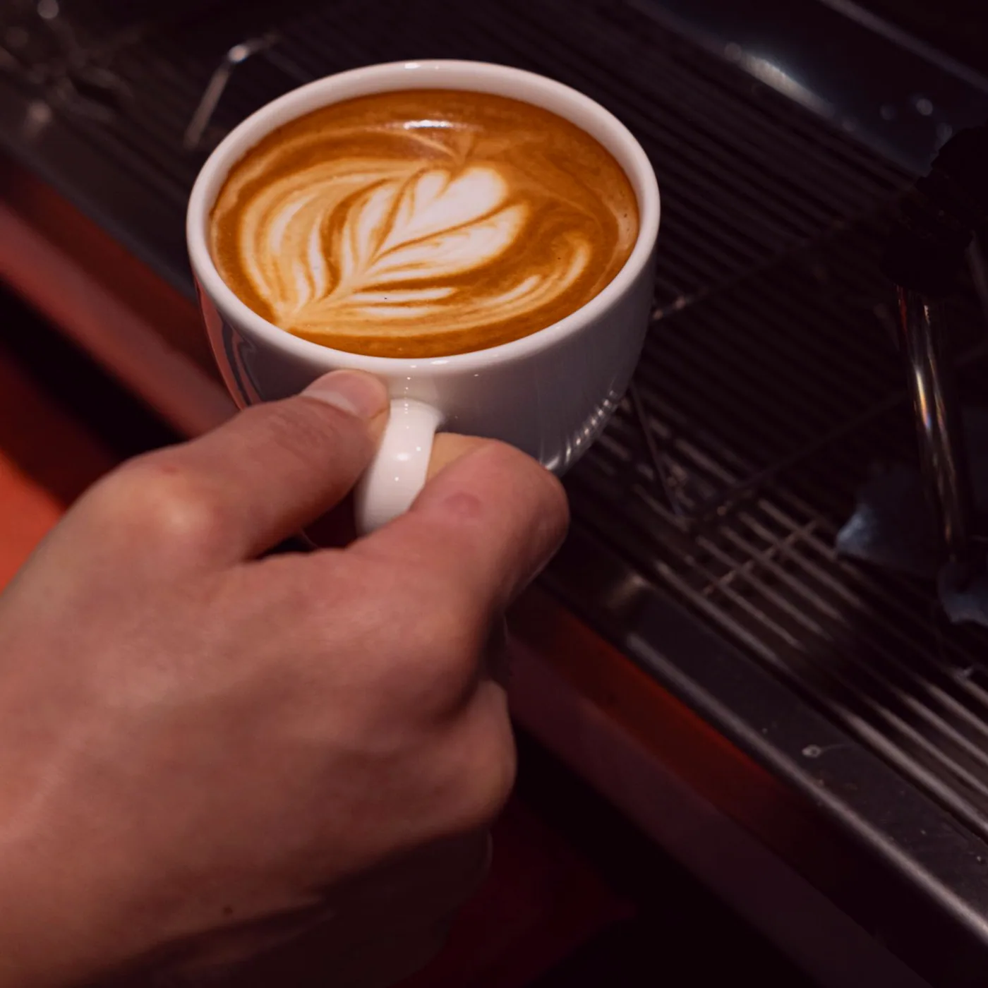 A mug of coffee left on the windowsill between hands.